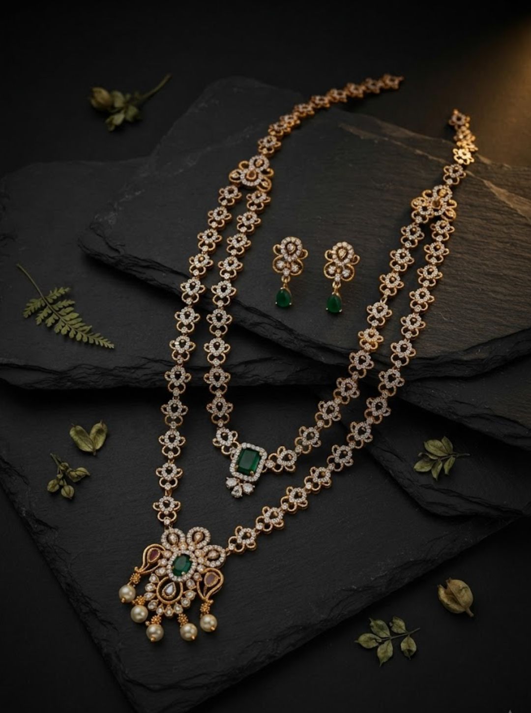 Designer floral necklace with sparkling stone detailing and a prominent rectangular green gemstone pendant.