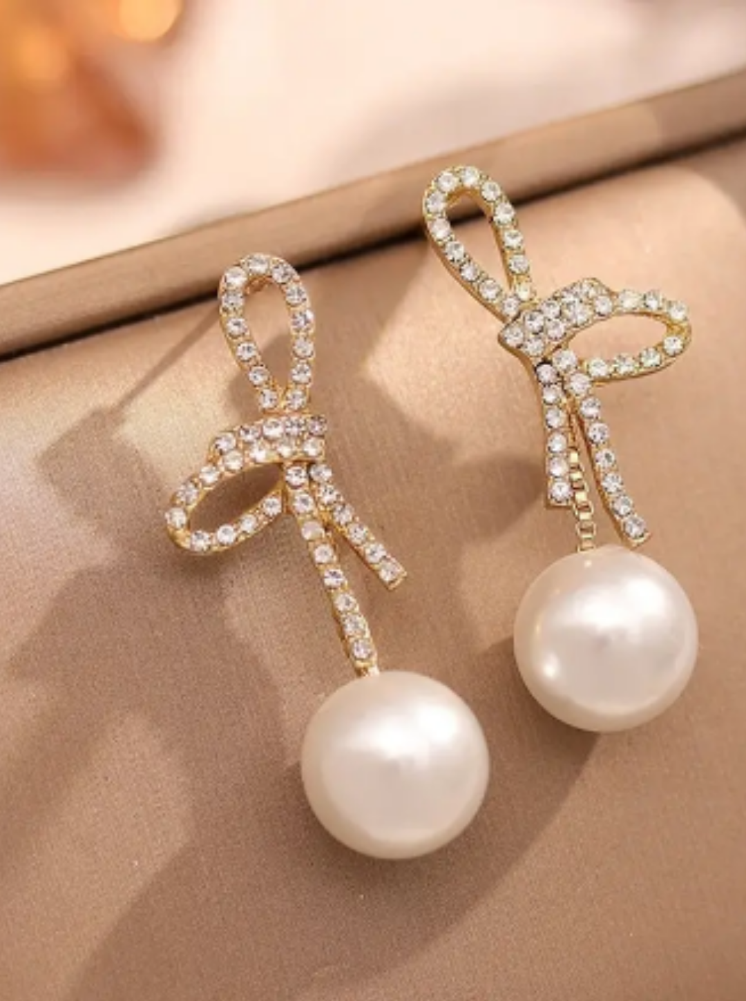Sparkling crystal bow earrings with large pearl drop