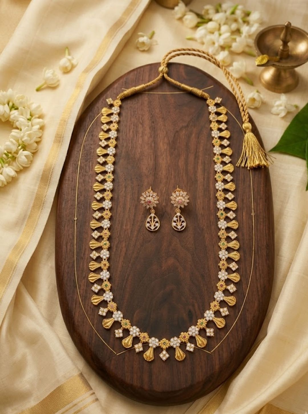 South Indian-inspired long necklace featuring floral clusters, fan-shaped gold motifs and matching drop earrings.
