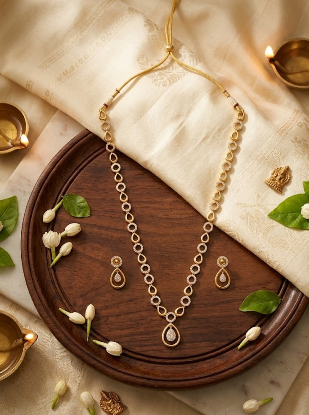 Contemporary gold-toned necklace with alternating circular and teardrop links on black slate.