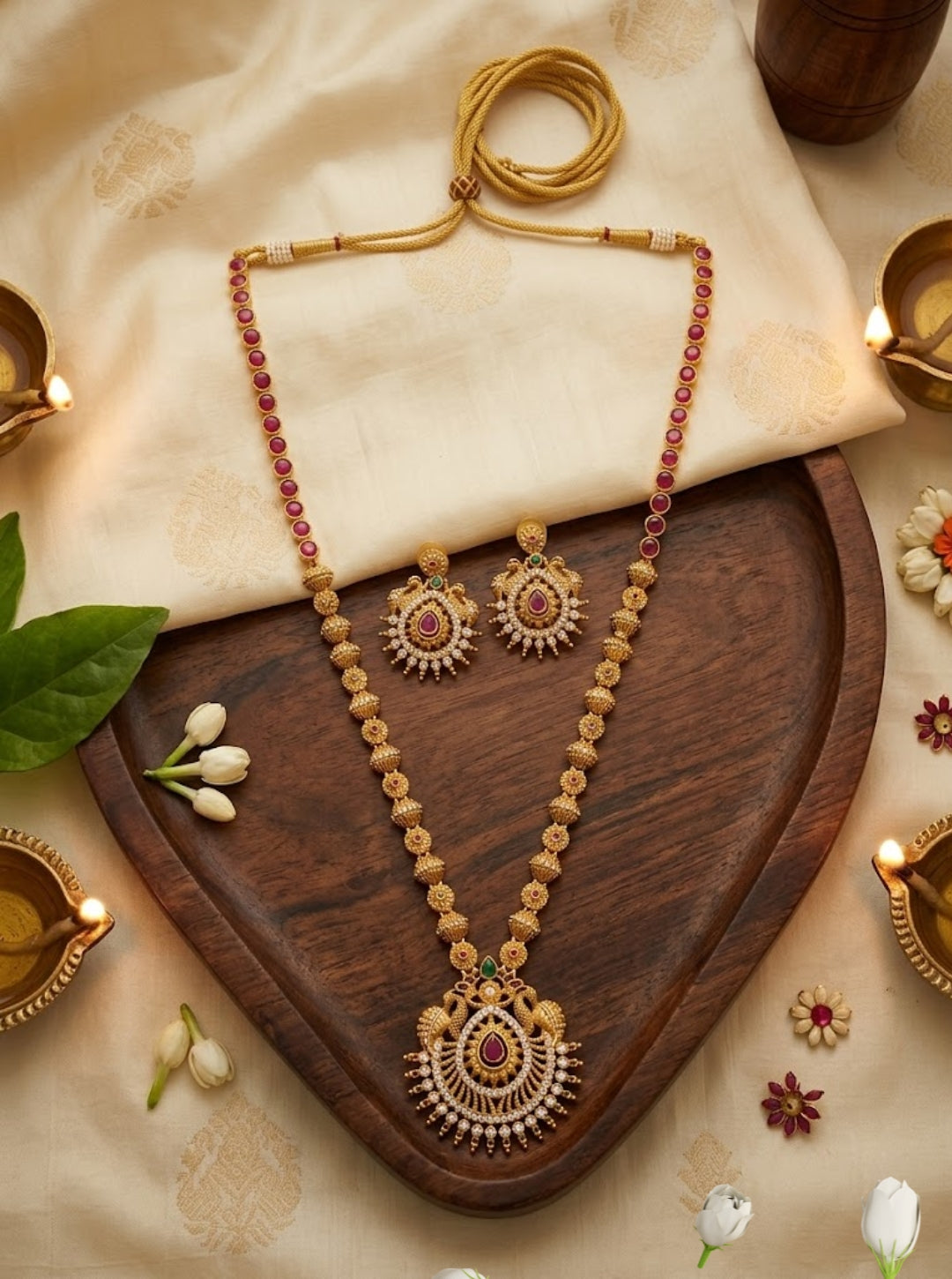 South Indian long necklace set featuring golden beads, ruby accents, and matching stud earrings.