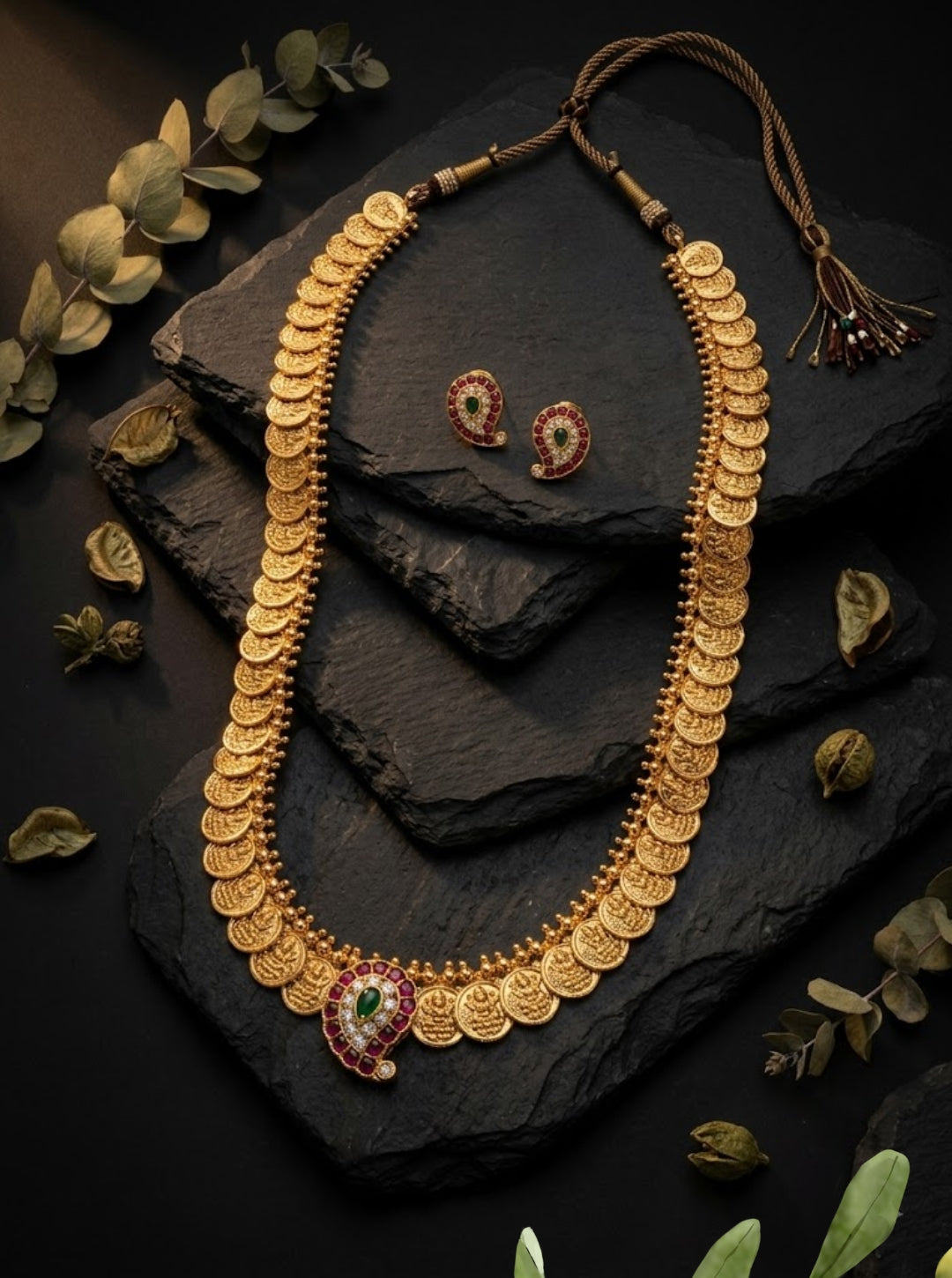 Gold coin necklace featuring Lakshmi motifs and red-green stone embellished mango pendant.